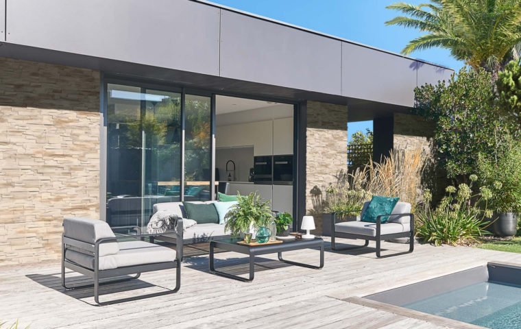 Maison d'architecte moderne ornée de parement GAIA avec terrasse en bois et piscine creusée